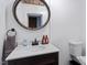 Modern bathroom with white cabinets, grey walls, decorative mirror, and modern fixtures at 1355 Bowling Road, Fuquay Varina, NC 27526