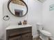 A cozy powder room with a rustic design, vanity sink, and a decorative mirror at 1355 Bowling Road, Fuquay Varina, NC 27526