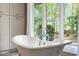 Bright bathroom showcasing a freestanding tub near a large window at 1355 Bowling Road, Fuquay Varina, NC 27526