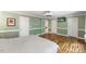 Open bedroom featuring doors, hardwood floors, and pale green walls at 1355 Bowling Road, Fuquay Varina, NC 27526