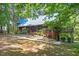 Charming wood home featuring a metal roof, lush landscaping, and a bridge connecting to the main structure at 1355 Bowling Road, Fuquay Varina, NC 27526