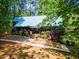 Charming wood home featuring a metal roof, lush landscaping, and a brick walkway to the front door at 1355 Bowling Road, Fuquay Varina, NC 27526