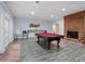 Game room with a red pool table, brick fireplace, and a doorway that leads to the backyard at 1355 Bowling Road, Fuquay Varina, NC 27526
