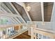 Bright upstairs hallway with white railings, wood floors, and vaulted ceilings showcasing modern design at 1355 Bowling Road, Fuquay Varina, NC 27526