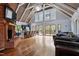 Open-concept living room with hardwood floors, high ceilings, fireplace, and access to the kitchen and deck at 1355 Bowling Road, Fuquay Varina, NC 27526