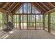 Relaxing screened porch with hanging chair overlooking a lush wooded area at 1355 Bowling Road, Fuquay Varina, NC 27526