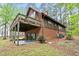 Back of house with a covered patio, upper deck, and sliding glass doors leading to a stone patio at 1355 Bowling Road, Fuquay Varina, NC 27526
