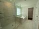 Modern bathroom featuring a glass-enclosed shower and a separate soaking tub with tile accents at 159 Yellow River Way, Garner, NC 27529
