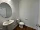 Clean half-bathroom with a pedestal sink, modern fixtures, and stylish wood-look flooring at 159 Yellow River Way, Garner, NC 27529