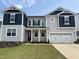 Two-story home with gray siding, dark blue accents, a well-kept lawn, and attached two car garage at 159 Yellow River Way, Garner, NC 27529