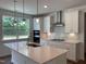 Modern kitchen features white cabinets, stainless steel appliances, a center island with sink, and stylish pendant lighting at 159 Yellow River Way, Garner, NC 27529