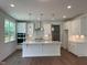 Bright kitchen featuring white cabinets, stainless steel appliances, a spacious island, and hardwood floors at 159 Yellow River Way, Garner, NC 27529