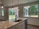 Kitchen island with sink, stainless steel dishwasher, pendant lights and a large window at 159 Yellow River Way, Garner, NC 27529