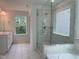 Luxurious main bathroom featuring dual vanities, a glass-enclosed shower, and a soaking tub at 159 Yellow River Way, Garner, NC 27529