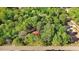 Aerial view of a wooded lot with mature trees and a house with a red roof at 1622 N Carolina 98 Hwy W, Louisburg, NC 27549
