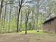 View of the home's spacious yard, featuring mature trees and partial brick exterior at 1622 N Carolina 98 Hwy W, Louisburg, NC 27549