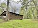 Backyard showing the brick home, propane tank, and green, wooded lot at 1622 N Carolina 98 Hwy W, Louisburg, NC 27549
