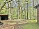 Backyard of home showing an outbuilding and surrounding mature trees at 1622 N Carolina 98 Hwy W, Louisburg, NC 27549