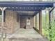 View of covered patio area with brick siding, support beams and a concrete floor at 1622 N Carolina 98 Hwy W, Louisburg, NC 27549