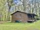 View of a brick house with covered porch, red metal roof, and surrounding greenery at 1622 N Carolina 98 Hwy W, Louisburg, NC 27549