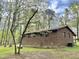 View of exterior side and rear of a brick home with green grass and mature trees at 1622 N Carolina 98 Hwy W, Louisburg, NC 27549