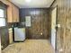 Laundry room featuring wood paneled walls, overhead cabinets, and laundry appliances at 1622 N Carolina 98 Hwy W, Louisburg, NC 27549