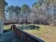 Expansive backyard view from a deck, showcasing a mature tree line, bench, and fire pit at 20 Willows Den Ct, Youngsville, NC 27596