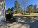 Landscaped front yard with trees, bushes, and a concrete walkway leading to the home at 20 Willows Den Ct, Youngsville, NC 27596