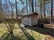 Backyard shed for extra storage, surrounded by mature trees, providing shade and privacy at 20 Willows Den Ct, Youngsville, NC 27596