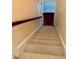 Carpeted staircase with a wooden handrail, leading to the next level of the home at 20 Willows Den Ct, Youngsville, NC 27596