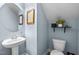 Charming powder room with pedestal sink, neutral paint, and stylish decor at 2007 Watson Rd, Durham, NC 27704