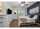 Cozy bedroom featuring a decorative accent wall, ceiling fan, and natural light at 2007 Watson Rd, Durham, NC 27704