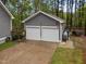 Detached two-car garage with white doors and gray siding next to a lawn at 2007 Watson Rd, Durham, NC 27704