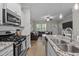 Open-concept kitchen features granite countertops, stainless steel appliances, and bright lighting at 2007 Watson Rd, Durham, NC 27704