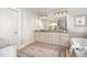 Elegant bathroom boasts granite countertop vanity, decorative rug and soaking tub at 214 Lions Gate Dr, Cary, NC 27518
