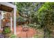 Charming brick patio features a table and chairs, surrounded by a lush garden with mature trees at 214 Lions Gate Dr, Cary, NC 27518