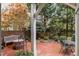 Brick patio with a bench, table, and garden accents surrounded by lush landscaping and mature trees at 214 Lions Gate Dr, Cary, NC 27518