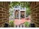 Charming brick patio offering a peaceful retreat with lush greenery and access to inviting outdoor spaces at 214 Lions Gate Dr, Cary, NC 27518