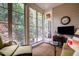 Inviting sunroom with large windows offering scenic views, fireplace, and comfortable seating area at 214 Lions Gate Dr, Cary, NC 27518
