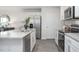 Bright kitchen features stainless steel appliances, gray cabinets, and a spacious island perfect for entertaining at 2145 Monk Dr, Haw River, NC 27258