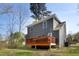 Backyard view with a wooden deck surrounded by green grass and trees at 218 Archdale Dr, Durham, NC 27707