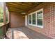 Covered back porch featuring a wood floor, brick walls, a fan, and a white door at 222 Lions Gate Dr, Cary, NC 27518