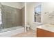 Bathroom with a shower-tub combination with glass door, tile flooring, and a window providing natural light at 222 Lions Gate Dr, Cary, NC 27518