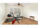 Exercise room featuring a ceiling fan, neutral walls, wood floors, and natural light from three windows at 222 Lions Gate Dr, Cary, NC 27518