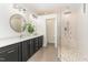Spa-like main bathroom with dual vanities, round mirrors, quartz countertop, and glass-enclosed shower at 222 Lions Gate Dr, Cary, NC 27518