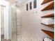 Elegant shower with a mosaic tile floor, rainfall shower head, and teak shelving for a luxurious experience at 222 Lions Gate Dr, Cary, NC 27518