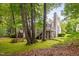 Backyard view of the house, featuring a deck, stairs, trees and lawn at 227 Chimney Rise Dr, Cary, NC 27511