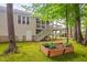 Backyard view of the house, featuring a deck, stairs, trees, a planter box and lawn at 227 Chimney Rise Dr, Cary, NC 27511