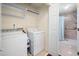 Convenient laundry room with washer, dryer, and storage shelves near bathroom at 227 Chimney Rise Dr, Cary, NC 27511