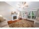 Cozy living room featuring a fireplace, ceiling fan, and hardwood floors with a decorative rug at 227 Chimney Rise Dr, Cary, NC 27511